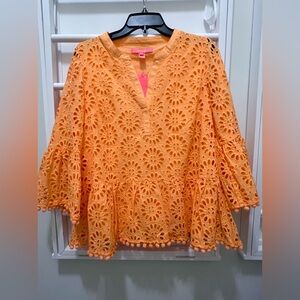 Lilly Pulitzer pinwheel eyelet with bell sleeves and pompom detail.